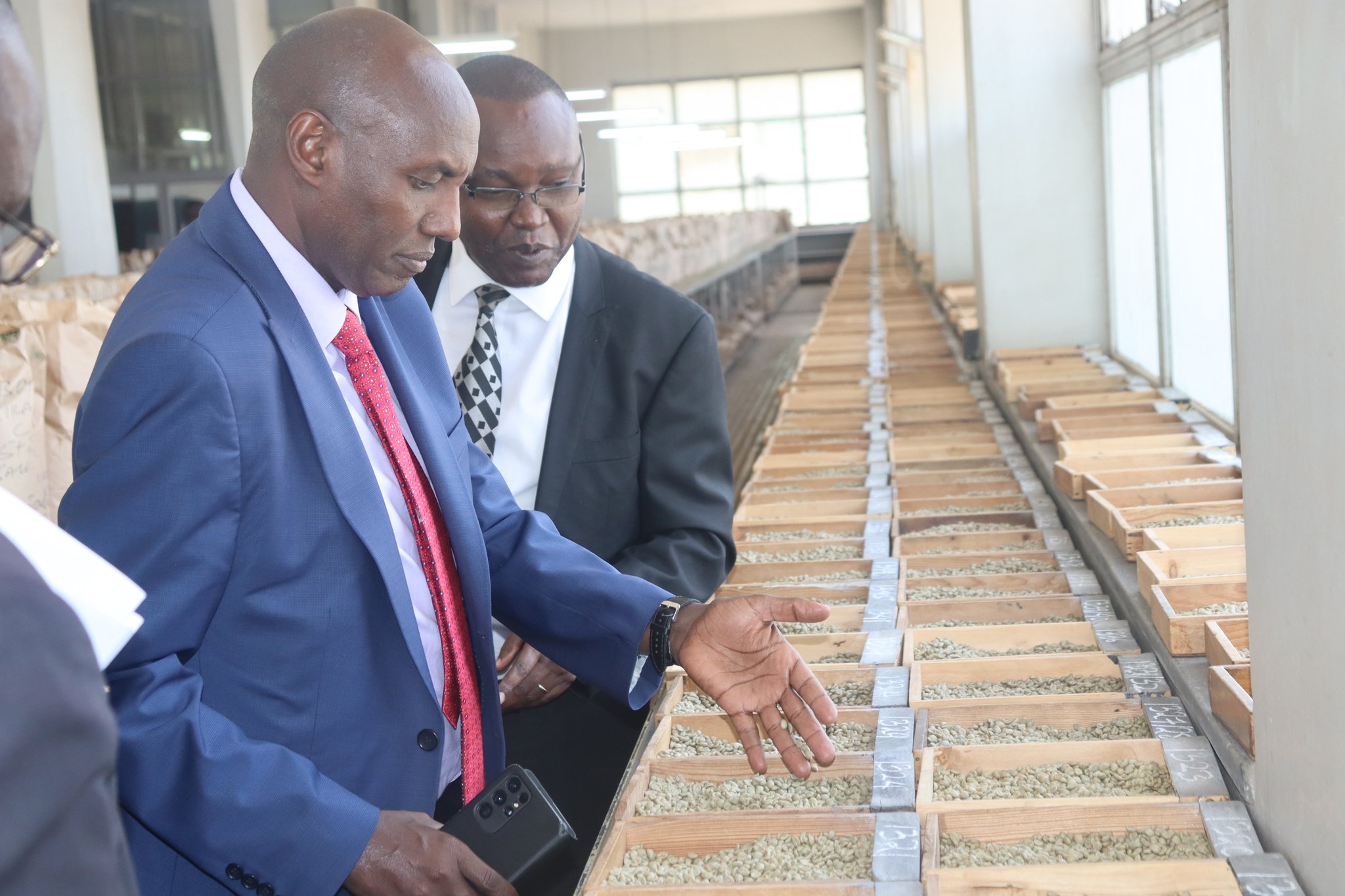 Former Agriculture Principal Secretary Harsama Kello (left) and former NCE chief executive officer Daniel Mbithi at auction sample room. Photo (NCE).